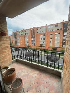 un balcón con macetas frente a un edificio en Acogedor apartamento en norte - 2 habitaciones, en Bogotá