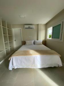 1 cama grande en un dormitorio con ventana en Casa de alto padrão em Antunes - Maragogi, en Maragogi