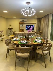 una sala da pranzo con tavolo e sedie in legno di Casa de alto padrão em Antunes - Maragogi a Maragogi