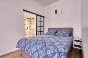 Schlafzimmer mit einem Bett mit einer blauen und weißen Bettdecke in der Unterkunft Roadway II- Silniczna in Kielce