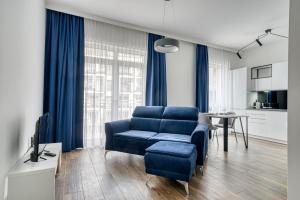 ein Wohnzimmer mit einem blauen Sofa und einem Tisch in der Unterkunft Roadway II- Silniczna in Kielce