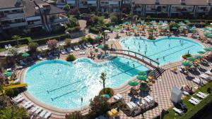 eine Aussicht auf einen Pool in einem Resort in der Unterkunft Perla Apartment - 3 piscine e un bar - Desenzano in Desenzano del Garda