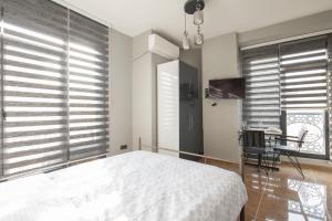 a bedroom with a bed and a desk and windows at Beyoğlu Huzur Apart in Istanbul