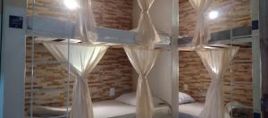 two bunk beds with white curtains in a room at Alvorada Guest House in Caxambu +8 photos
