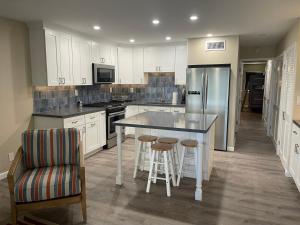 a kitchen with white cabinets and a island with bar stools at Sun-Days at Crystal Cove on Sapphire Beach in East End