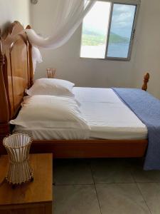 a bedroom with a large bed with a window at Chez Antonin in Bouillante