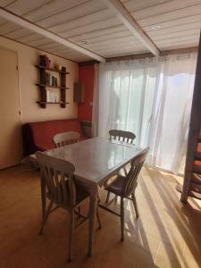 einen Tisch und Stühle in einem Zimmer mit einem Schlafzimmer in der Unterkunft Maison de plage in Narbonne-Plage