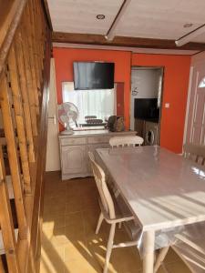 ein Esszimmer mit einem Tisch und einer Küche in der Unterkunft Maison de plage in Narbonne-Plage