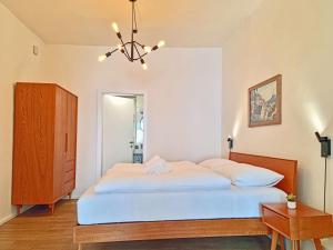 a bedroom with a large bed and a chandelier at Rosa Apartment with parking historic city center in Merano