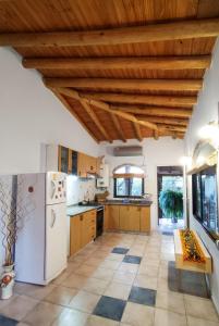 cocina con techos de madera y nevera blanca en Casa Luz y Armonía en Villa Las Rosas