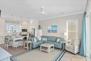 a living room with a blue couch and a kitchen at Isle of Dreams in Emerald Isle
