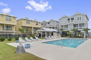 a swimming pool in a yard with houses at Isle of Dreams in Emerald Isle