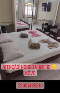 um quarto com 2 camas e toalhas em Pousada nascente do sol em Macaé