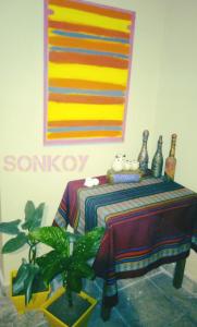 a table with a table cloth and a painting on the wall at SONKOY APART in San Salvador de Jujuy