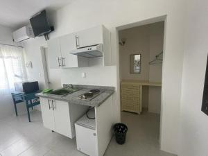 a kitchen with white cabinets and a sink and a desk at Loft. 202. Loft. 203. Loft. 208 in Acapulco