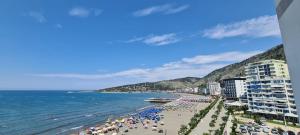 a beach with a bunch of people and the ocean at Sea view apartment 1 in Shëngjin +5 photos