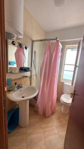 La salle de bains est pourvue d'un lavabo et de toilettes. dans l'établissement Sea view apartment 1, à Shëngjin