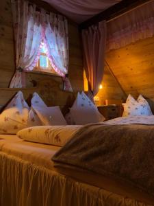 Un dormitorio con una cama con almohadas blancas y una ventana en Ferienhaus Pliescherhof, en Turnau