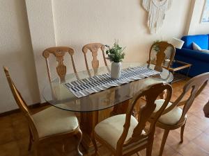 uma mesa de vidro com quatro cadeiras e um vaso com uma planta em Vive Rie Ama Tenerife - 2 bedroom apartment em San Miguel de Abona