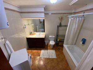 uma casa de banho com uma banheira, um lavatório e um WC. em Vive Rie Ama Tenerife - 2 bedroom apartment em San Miguel de Abona