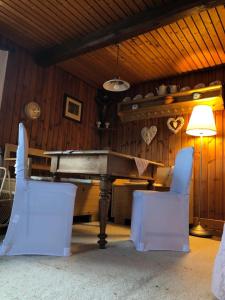 a ping pong table in a room with two white chairs at Ferienhaus Pliescherhof in Turnau