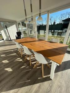 a wooden table with white chairs around it at Bungalow zwischen Wald und Seen in Pretzien