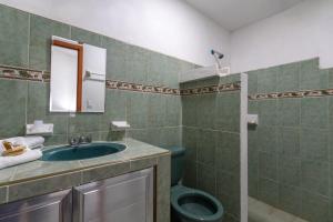 ein Badezimmer mit grünem WC und Waschbecken in der Unterkunft Mérida 62 in Mérida