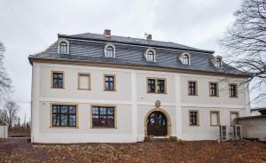 een groot wit huis met een gambrel dak bij Dwór Sędzisław 