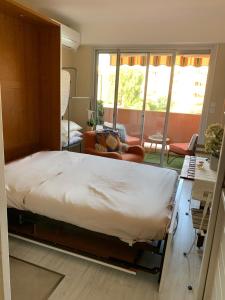 a bedroom with a large bed and a living room at My Little Provence Bormes Les Mimosas in Bormes-les-Mimosas