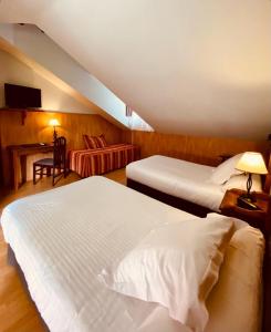 a hotel room with two beds and a desk at El Tejo de Comillas in Comillas