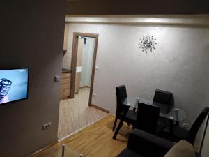 a dining room with a table and chairs and a television at Apartmani Kristina & Kriss in Užice