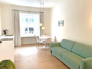 uma sala de estar com um sofá verde e uma mesa em Rosa Apartment with parking historic city center em Merano