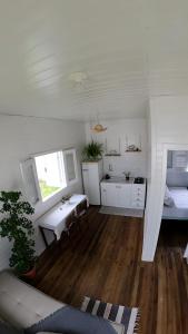 a white room with a table and a bed and a sink at A Casinha de Madeira in Balneário Gaivotas