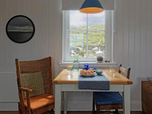 a dining room table with a plate of food and a window at Hona in Mangersta