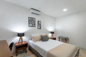 1 dormitorio con 1 cama, 2 mesitas de noche y 2 lámparas en Mérida 62, en Mérida