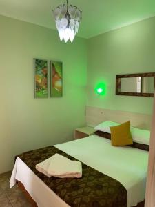 um quarto com 2 camas e um lustre em Pousada Krolow em Pelotas