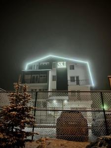 um edifício com uma placa à noite em Apartments and Rooms Ski em Vlasic
