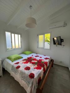 Un dormitorio con una cama grande con rosas rojas. en Glacière Paradise, en Bouillante