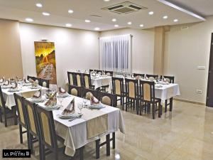La Pietra Family Hotel في ميديوغوريه: غرفة طعام مع طاولات وكراسي في مطعم