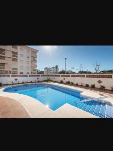 a large swimming pool in front of a building at Apartamento en el Portil in El Portil