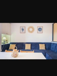 jadalnia ze stołem i niebieską kanapą w obiekcie Apartamento en el Portil w mieście El Portil