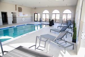 una gran piscina con sillas, una mesa y una piscina en Days Inn by Wyndham Amarillo - Medical Center, en Amarillo