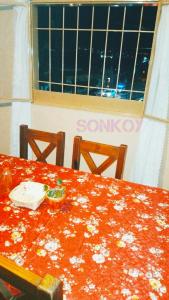 a table with a red table cloth with flowers on it at SONKOY APART in San Salvador de Jujuy