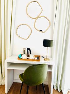 a green chair sitting next to a white desk with mirrors at Hotel Miramar in Port de Soller