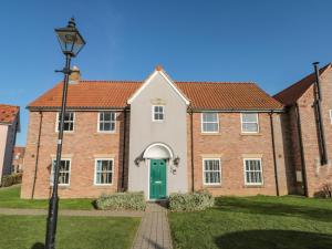 an old brick house with a green door at Rosie's Retreat in Filey