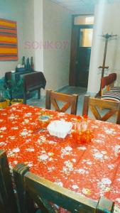 聖薩爾瓦多德胡胡伊的住宿－SONKOY APART，一张红色的画面上盖着鲜花的桌子