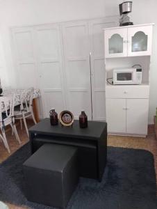 a living room with a table and a microwave at Monoambiente Full Equipado - La Bussola in Las Heras