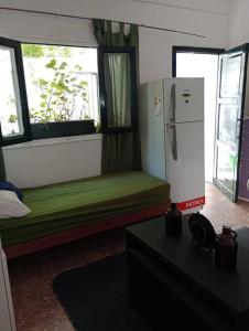 Las HerasにあるMonoambiente Full Equipado - La Bussolaの小さな客室で、冷蔵庫、緑のソファが備わります。