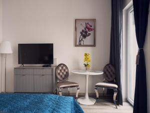 ein Schlafzimmer mit einem Tisch und 2 Stühlen sowie einem TV in der Unterkunft Prymasa Tysiąclecia 83A (D) by Perfect Apart in Warschau