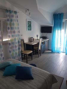 een slaapkamer met een bureau en een tafel met een bed bij Gabi Rooms & Studio Apartment in Lozovac